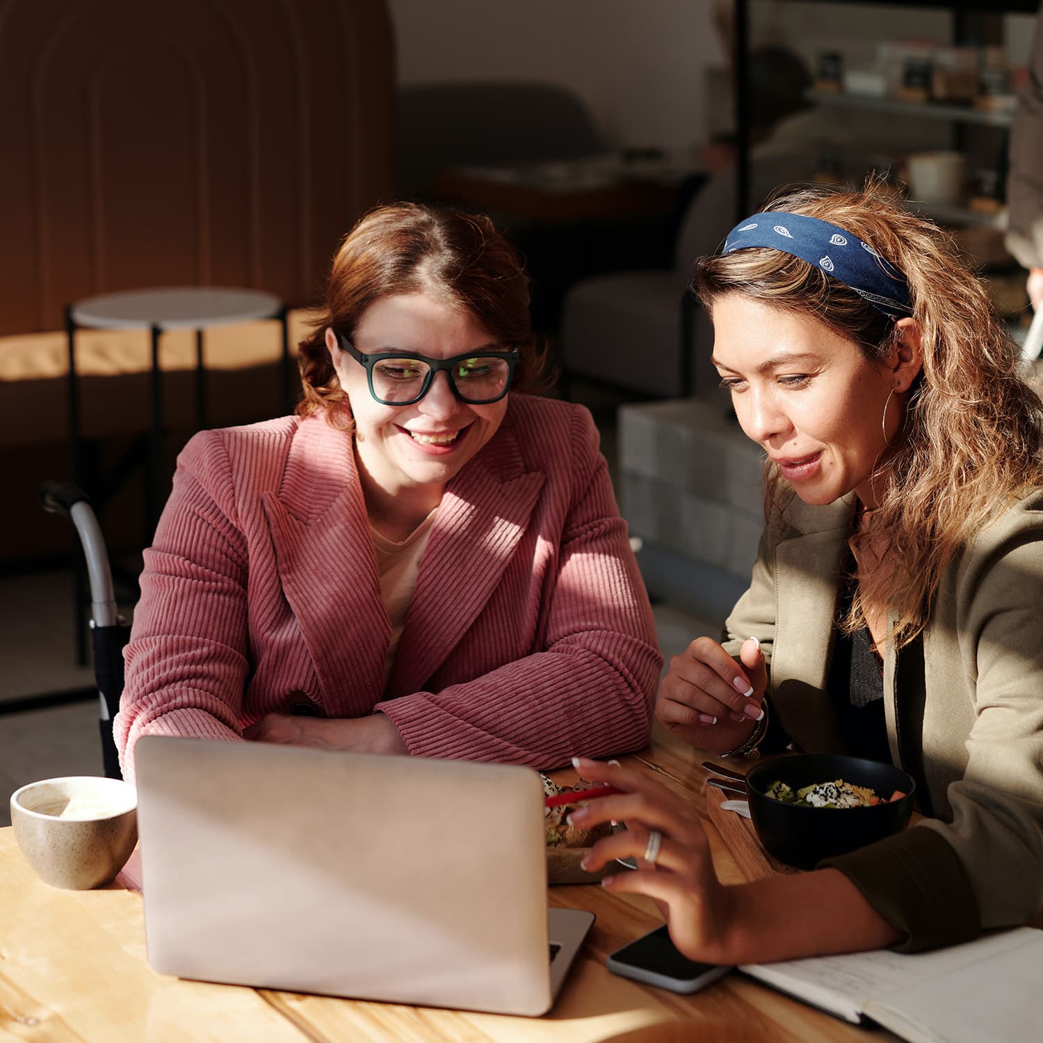 Two women interacting with laptop