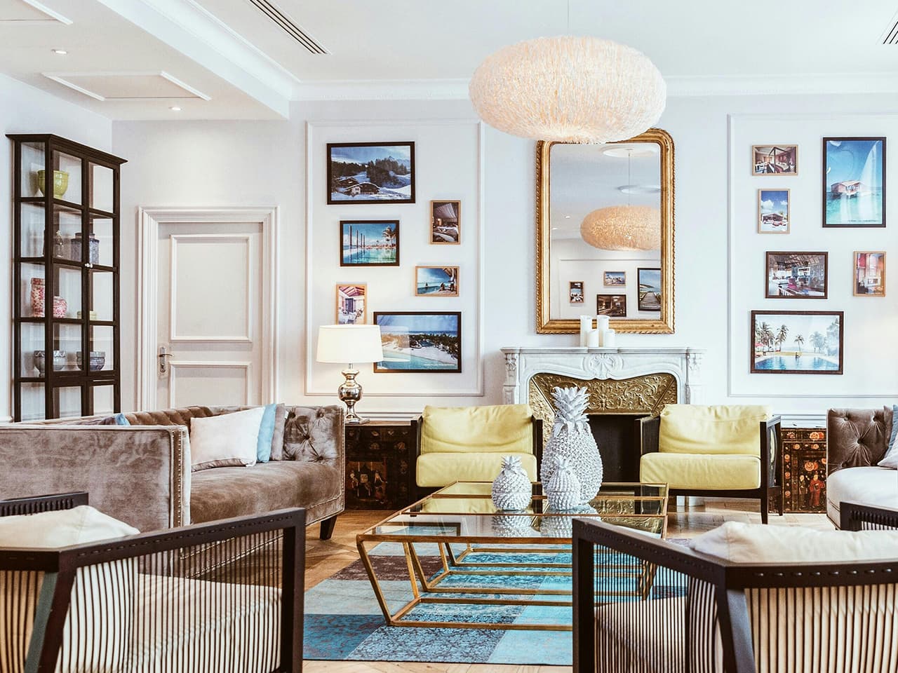 Living room in modern nostalgia style, with cream white walls, French style fireplace and charming collections of heirlooms and artwork.