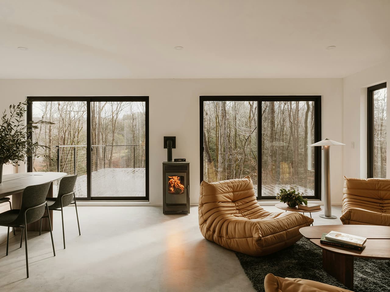 Cozy, minimalist interior with Togo armchairs in cognac coloured leather, contrasting shapes and textures.